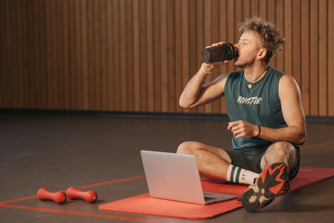 A fitness enthusiast preparing a protein shake to support muscle recovery.