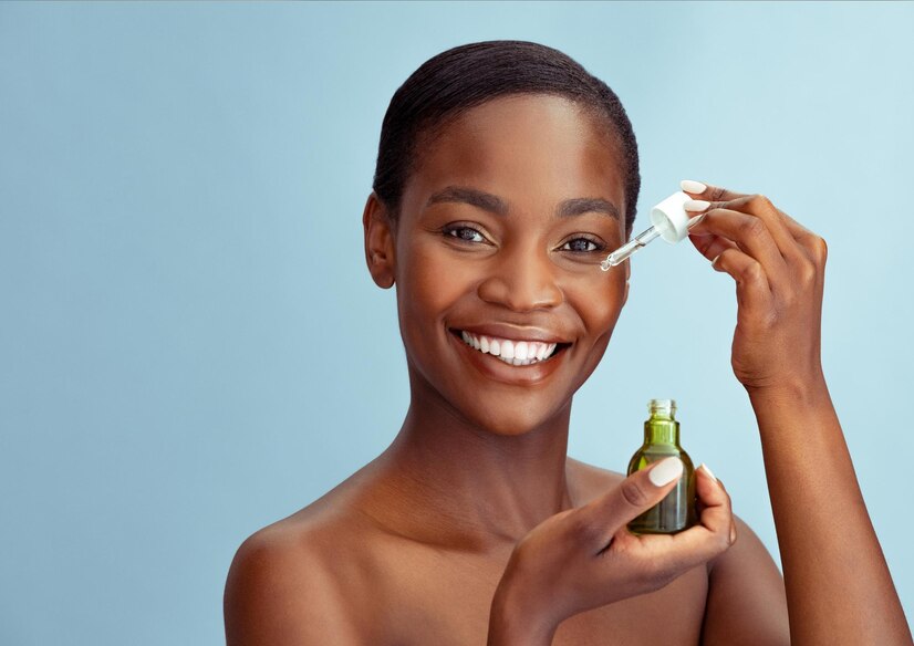 Black woman using natural oils to keep her skin radiant.