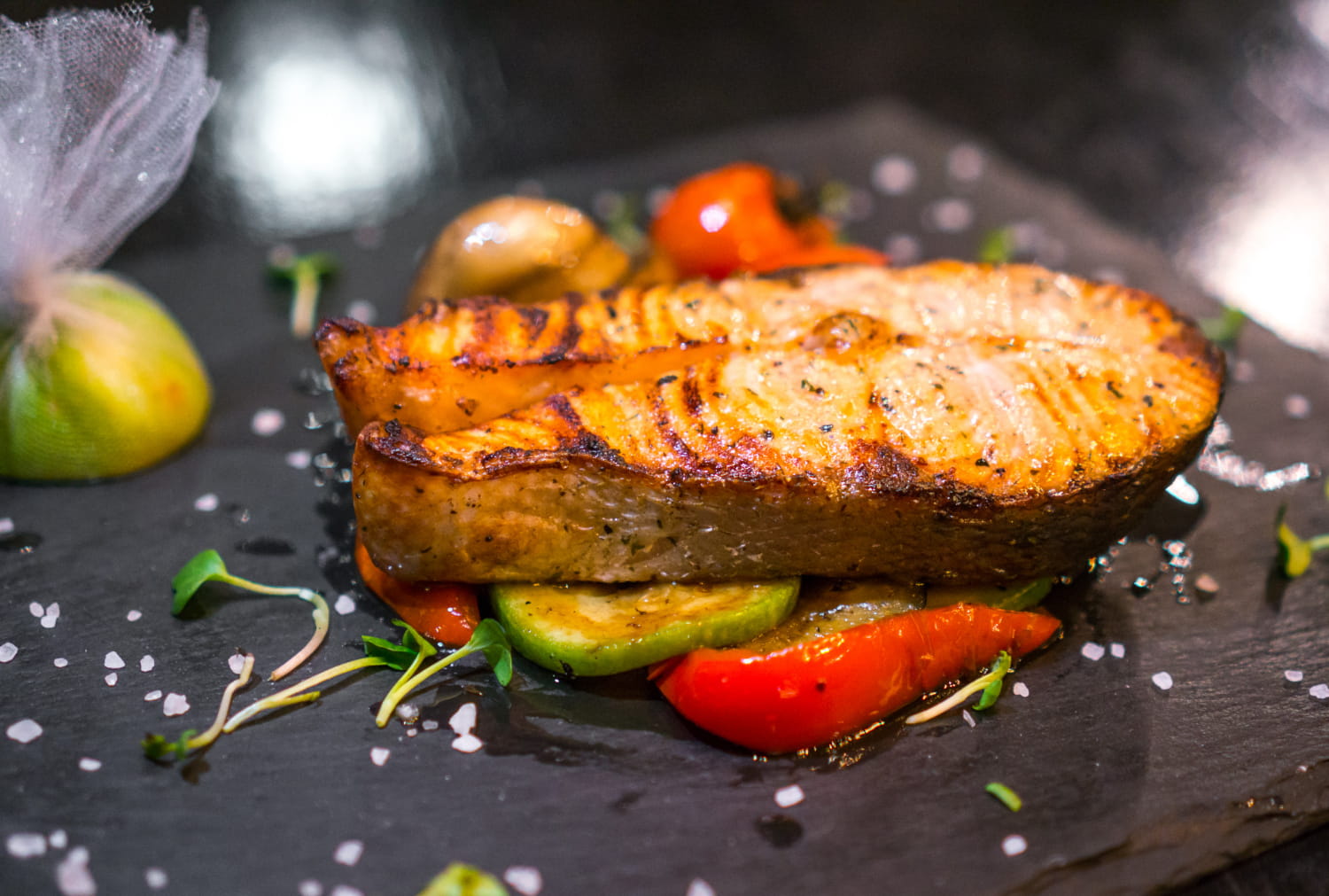 Grilled salmon fillet with lemon slices, emphasizing its nutritious value.